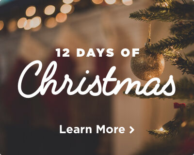 A decorated Christmas tree with a shimmering gold ornament. Soft white lights twinkle in the background. Image links to a page about the Twelve Days of Christmas song. 